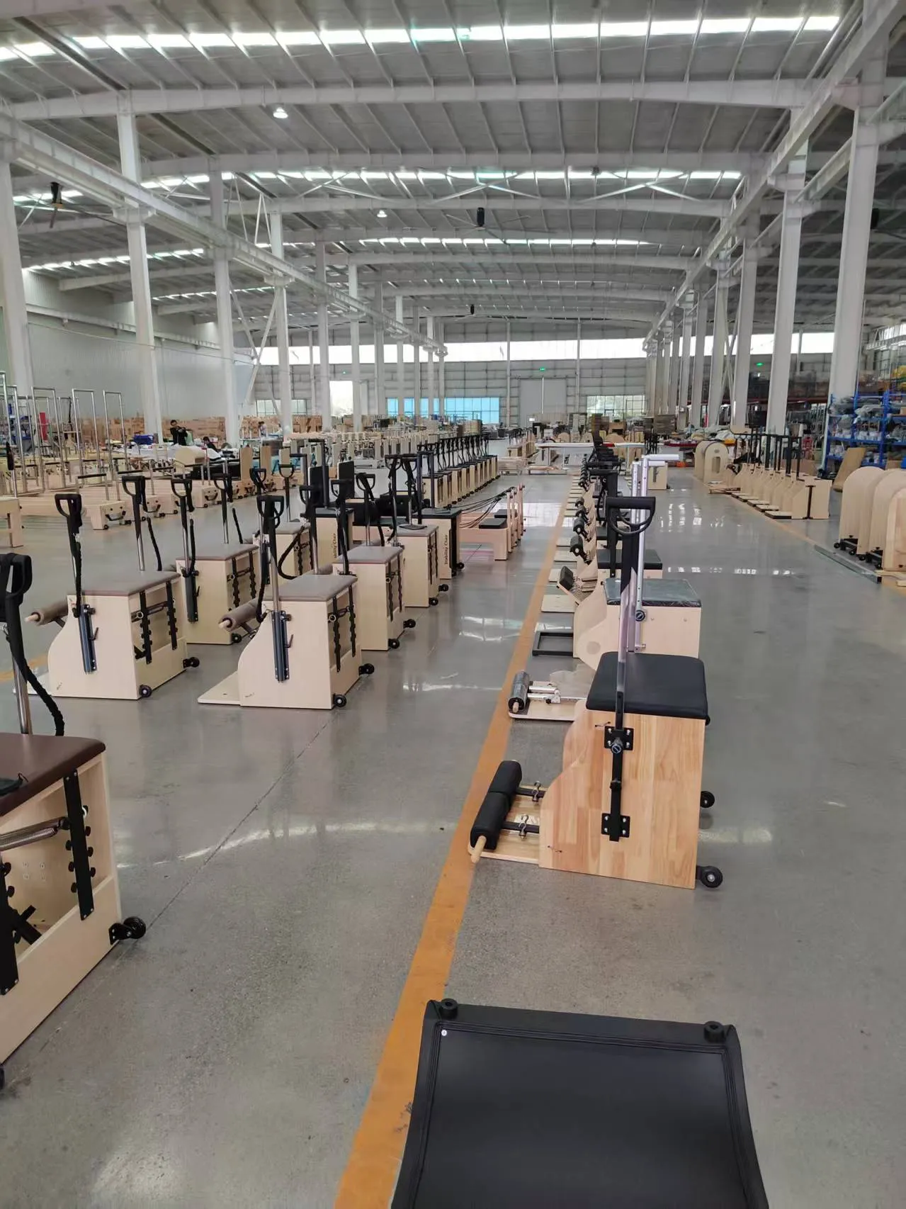 Lumina Pilates equipment production workshop with chairs and reformers