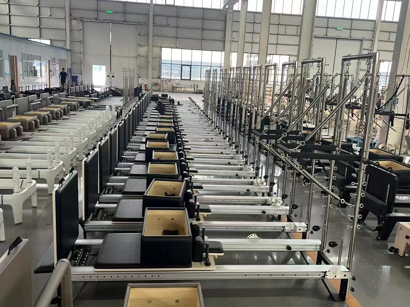 Aluminum Pilates reformers and Cadillac equipment aligned in factory