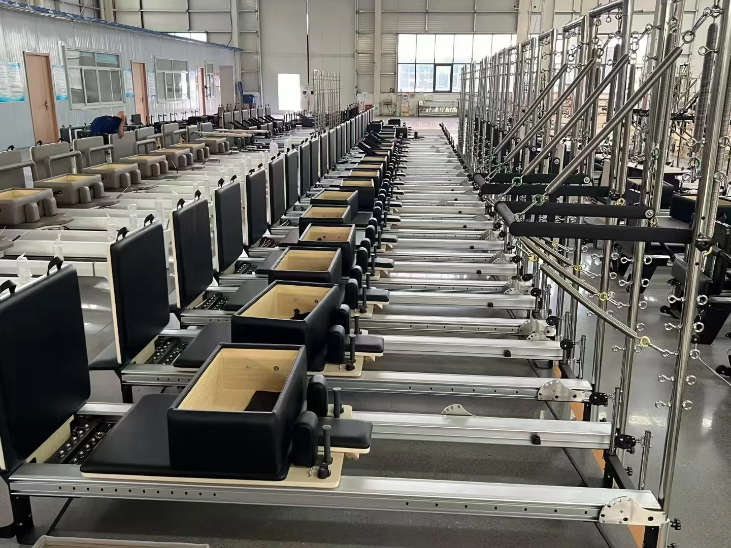 Close view of Pilates reformers with tower frames during production
