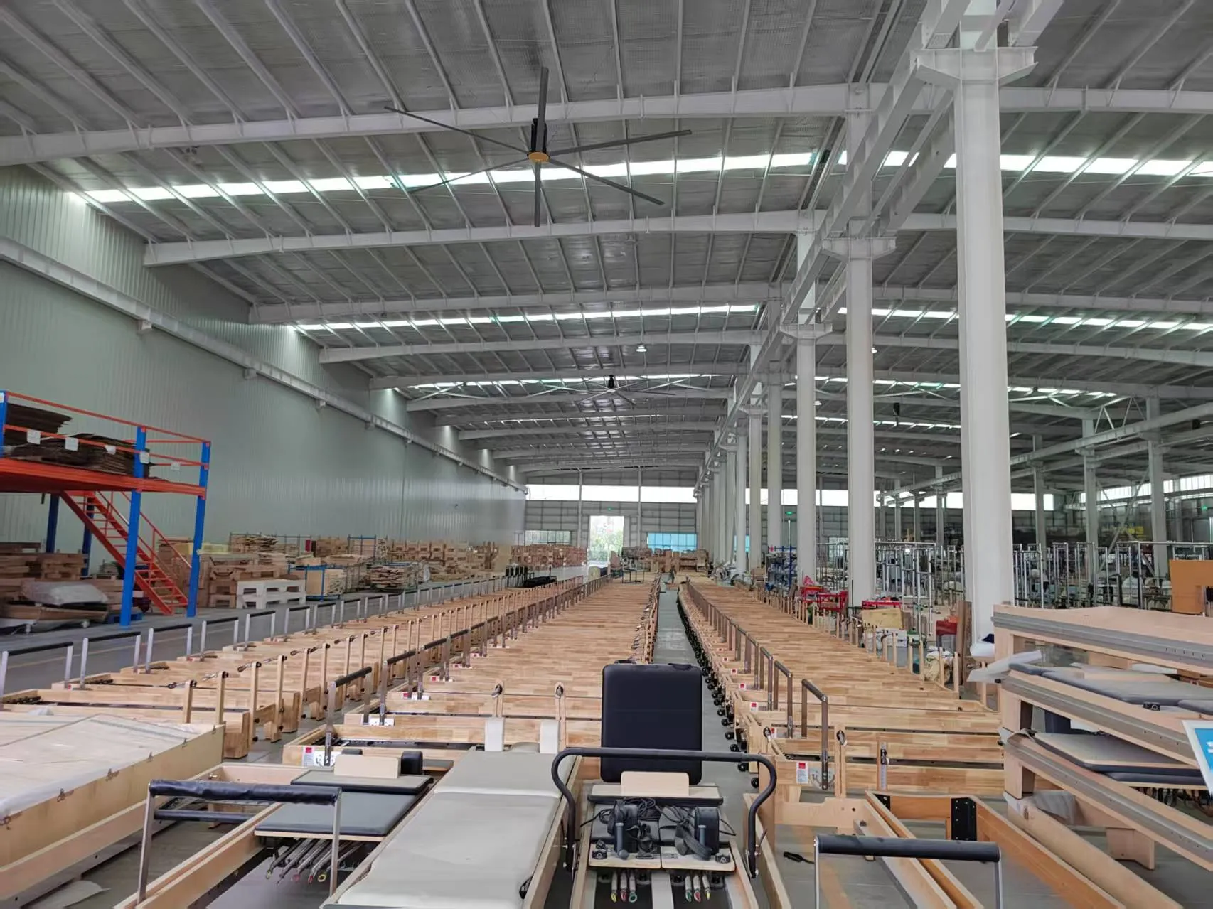 Long rows of wooden Pilates reformers ready for final checking